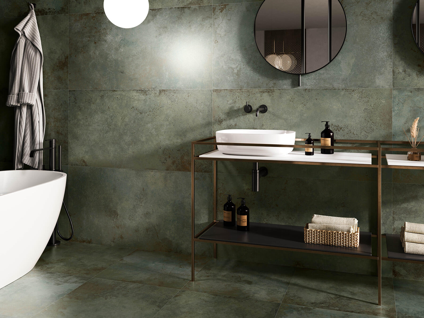 Modern bathroom with large rectangle tiles that are rustic deep green. White soaker tub and bronze metal vanity frame with white ink.
