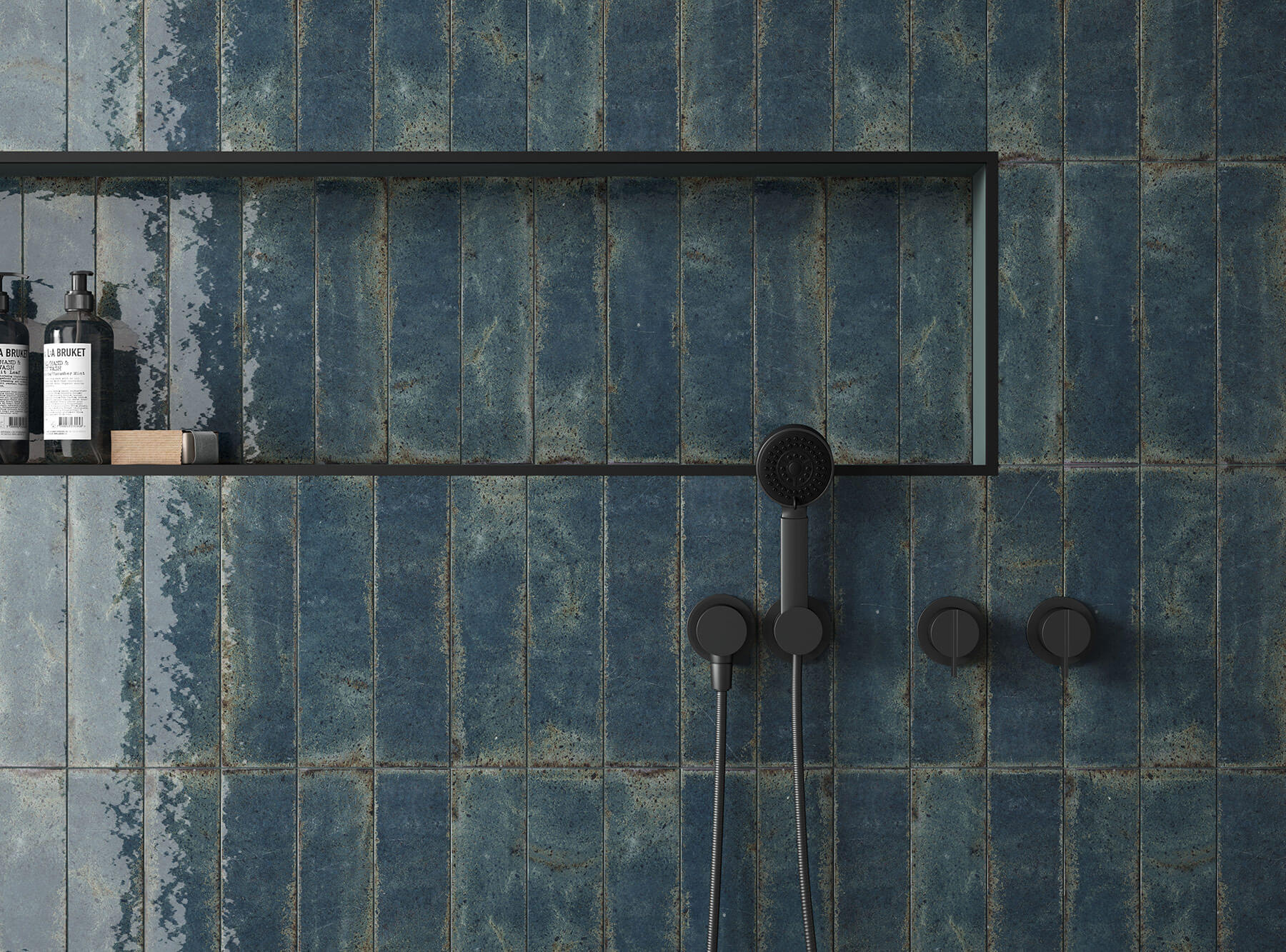 Close up of shower wall with handmade deep turquoise subway tiles, black tapware.