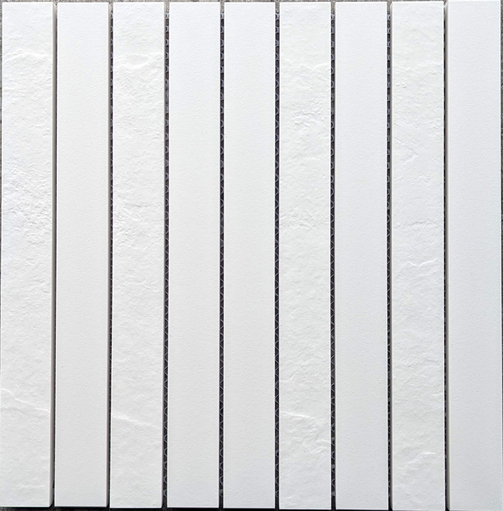 Close up of tall thin white tiles with texture surface.