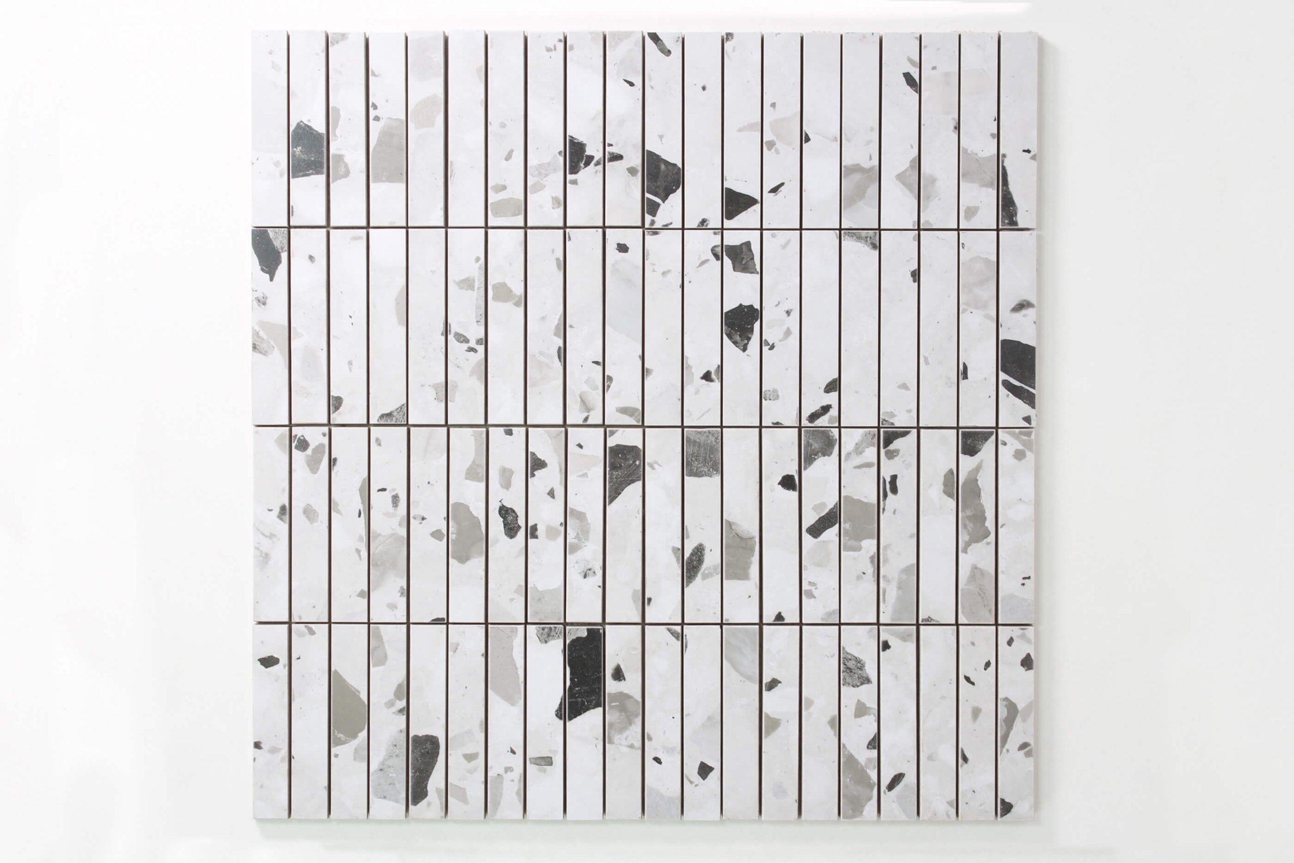 Close up of white tiles with grey and black speckle pattern.