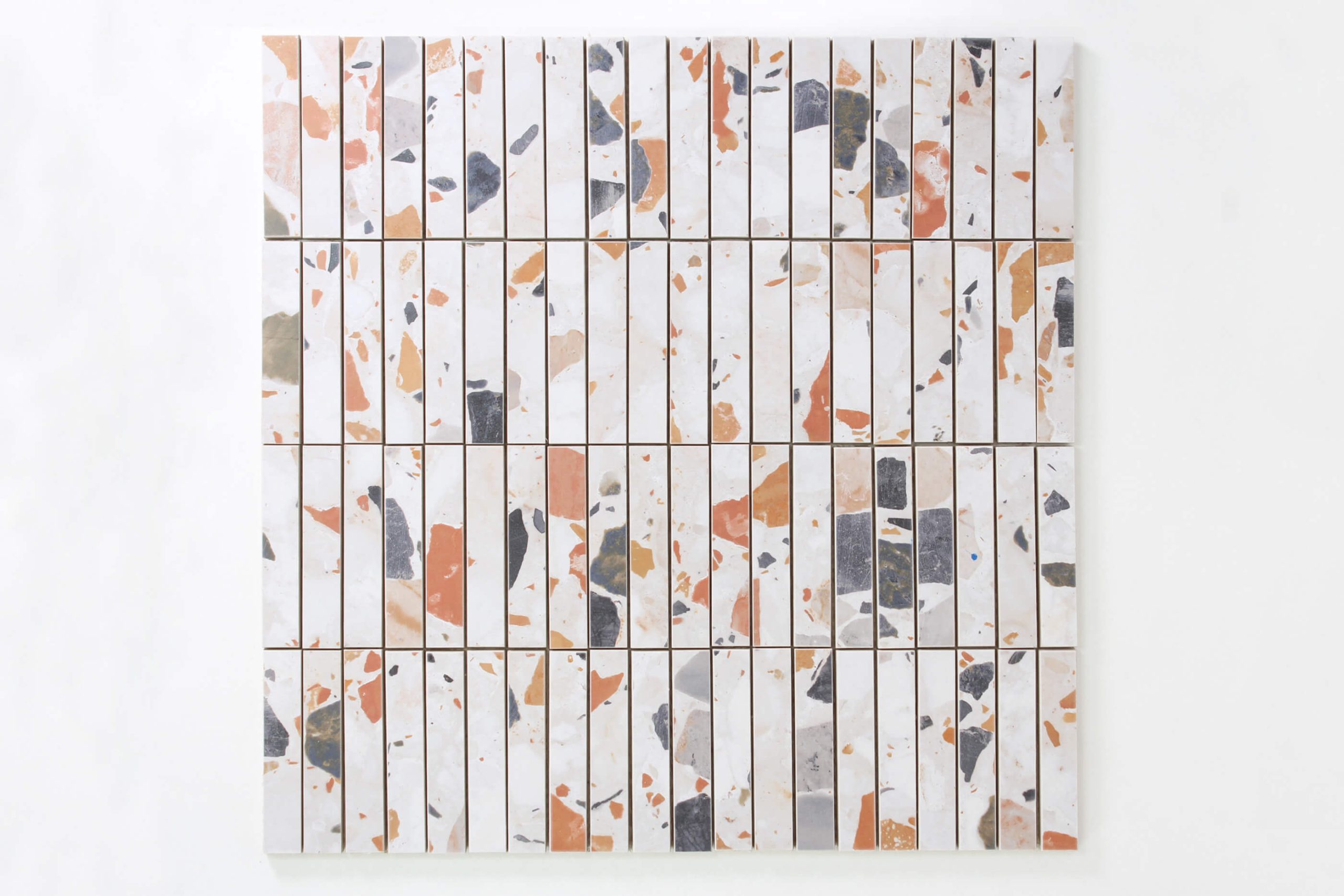 Close up of white tiles with grey, blue and peach speckle design.