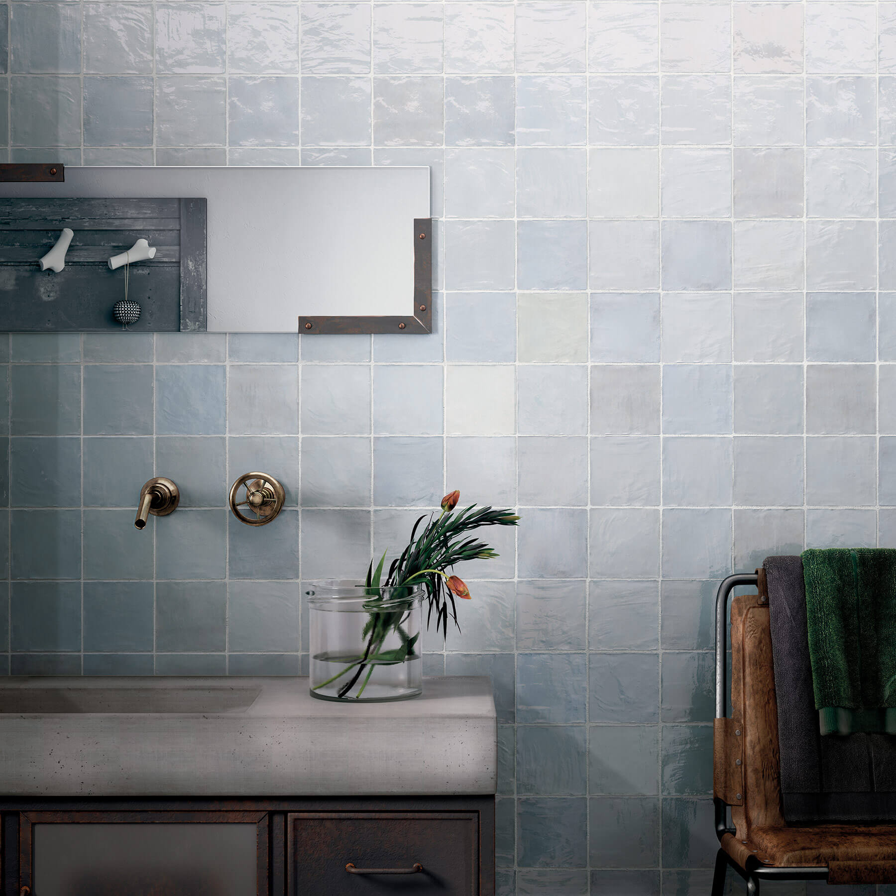 Close up of wall behind bathroom vanity showing small square soft blue tiles.