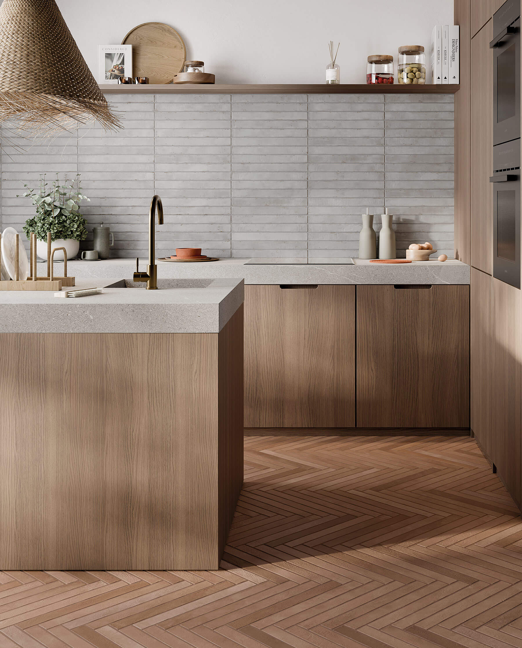 Kitchen with timber cabinets, stone benchtops, floor tiles that look like timber laid in herringbone pattern, and a feature wall of long grey subway tiles.