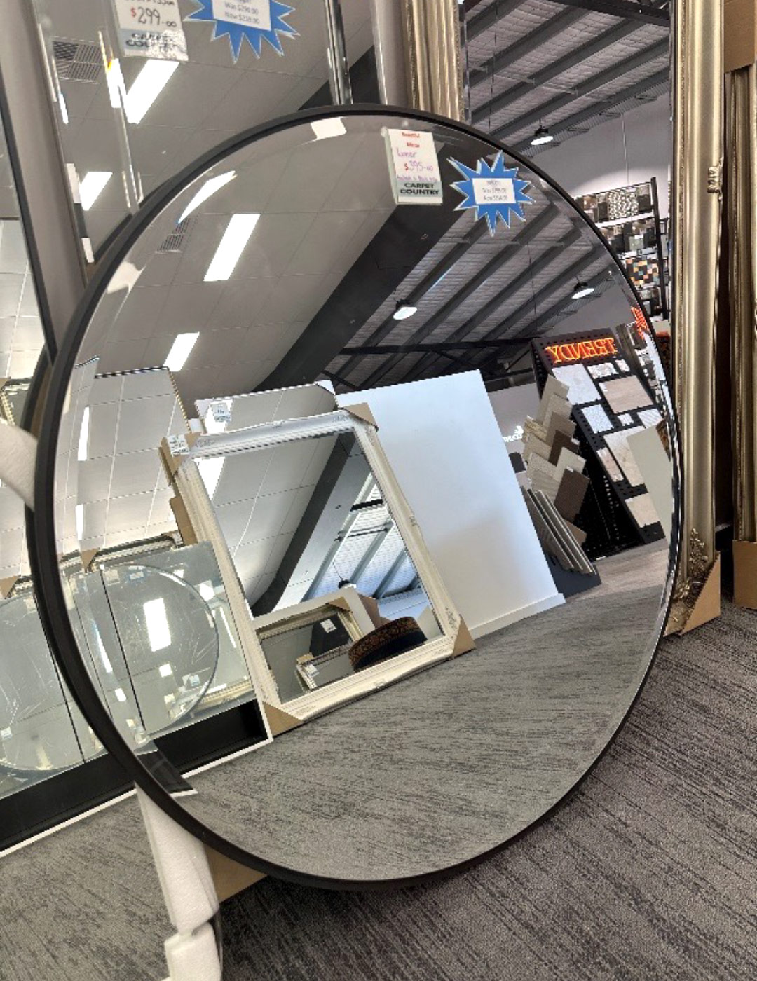 Small round mirror leaning against a wall in a store.