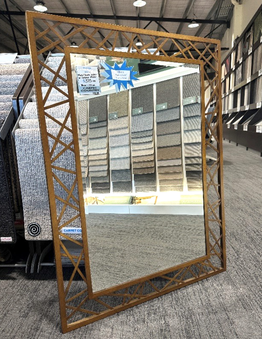 Small mirror with detailed gold metal frame in a store.