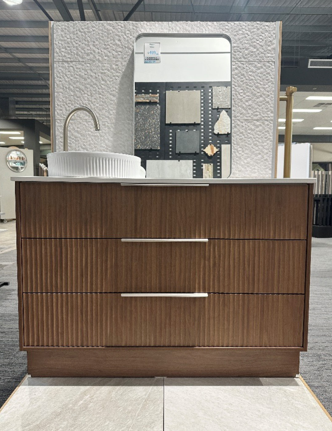 Timber vanity with three drawers, white top and white sink, on display in a store.
