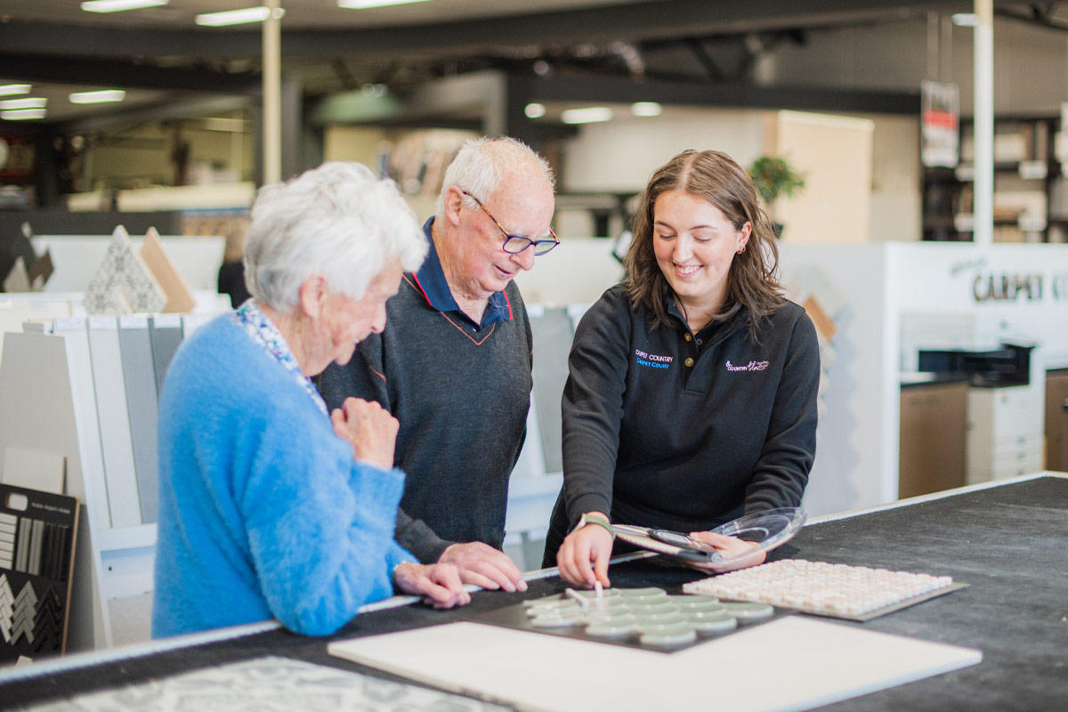 Laura Truscott showing tile options to customers in a tile shop.