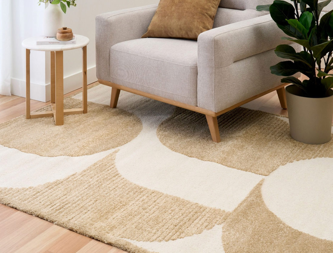 Cream colour floor rug with cream armchair on it.