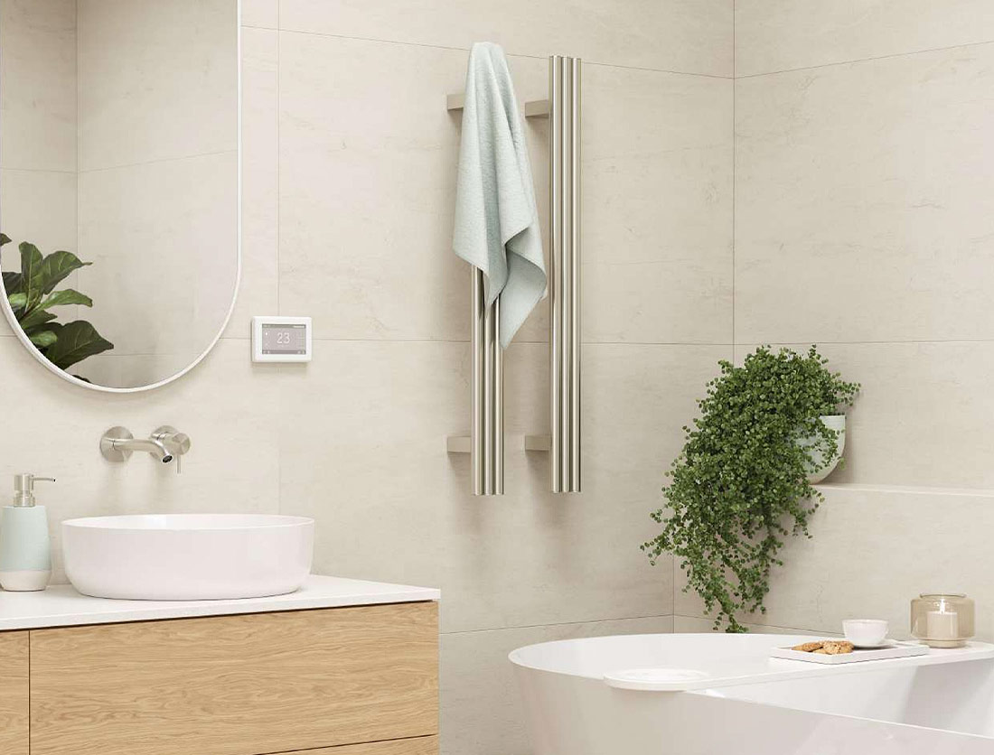 Contemporary heated towel rail on a light cream tile wall.