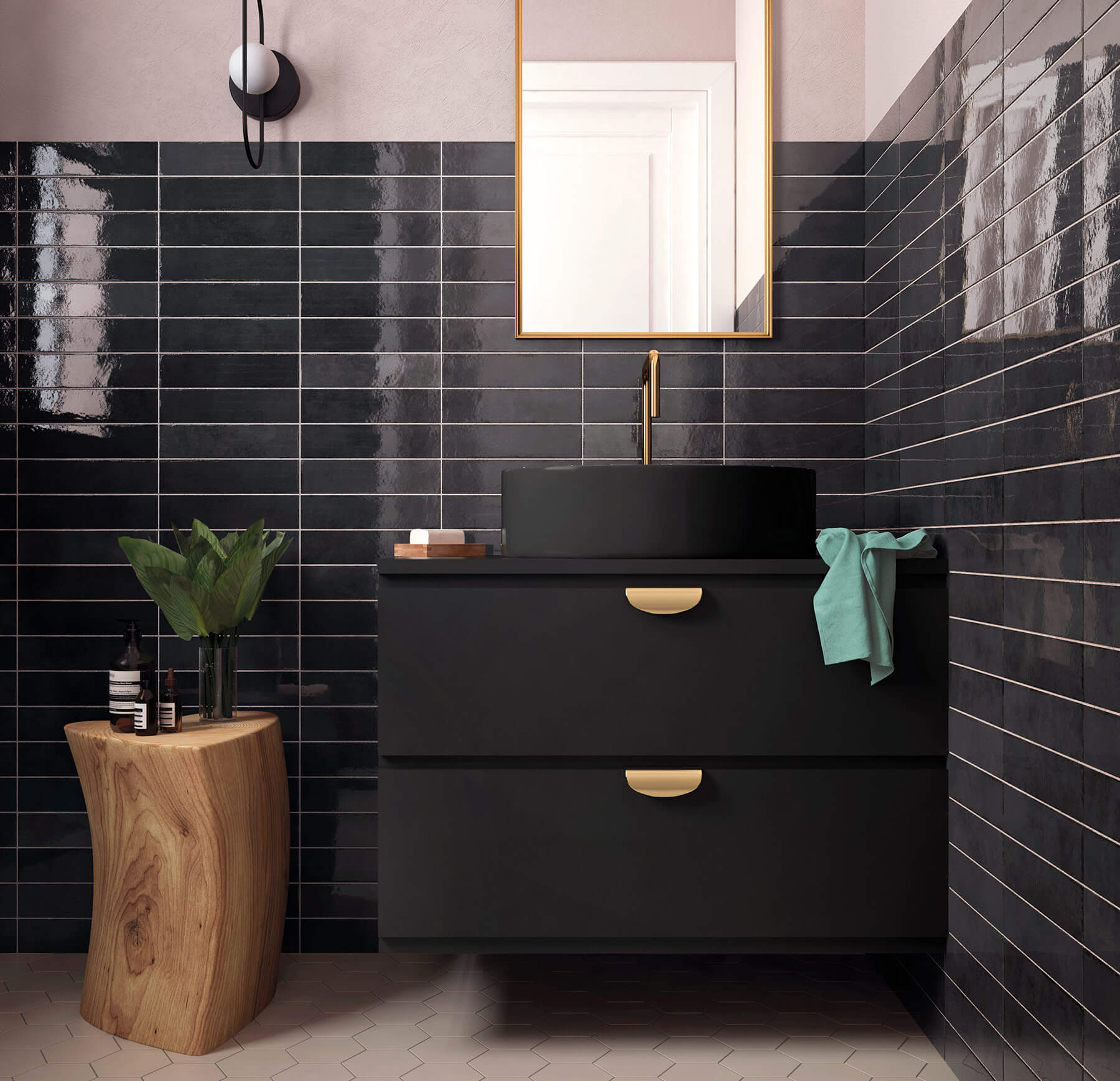 Close up of bathroom with black vanity, surrounded by glossy black subway tiles with white grout. Gold fixtures.