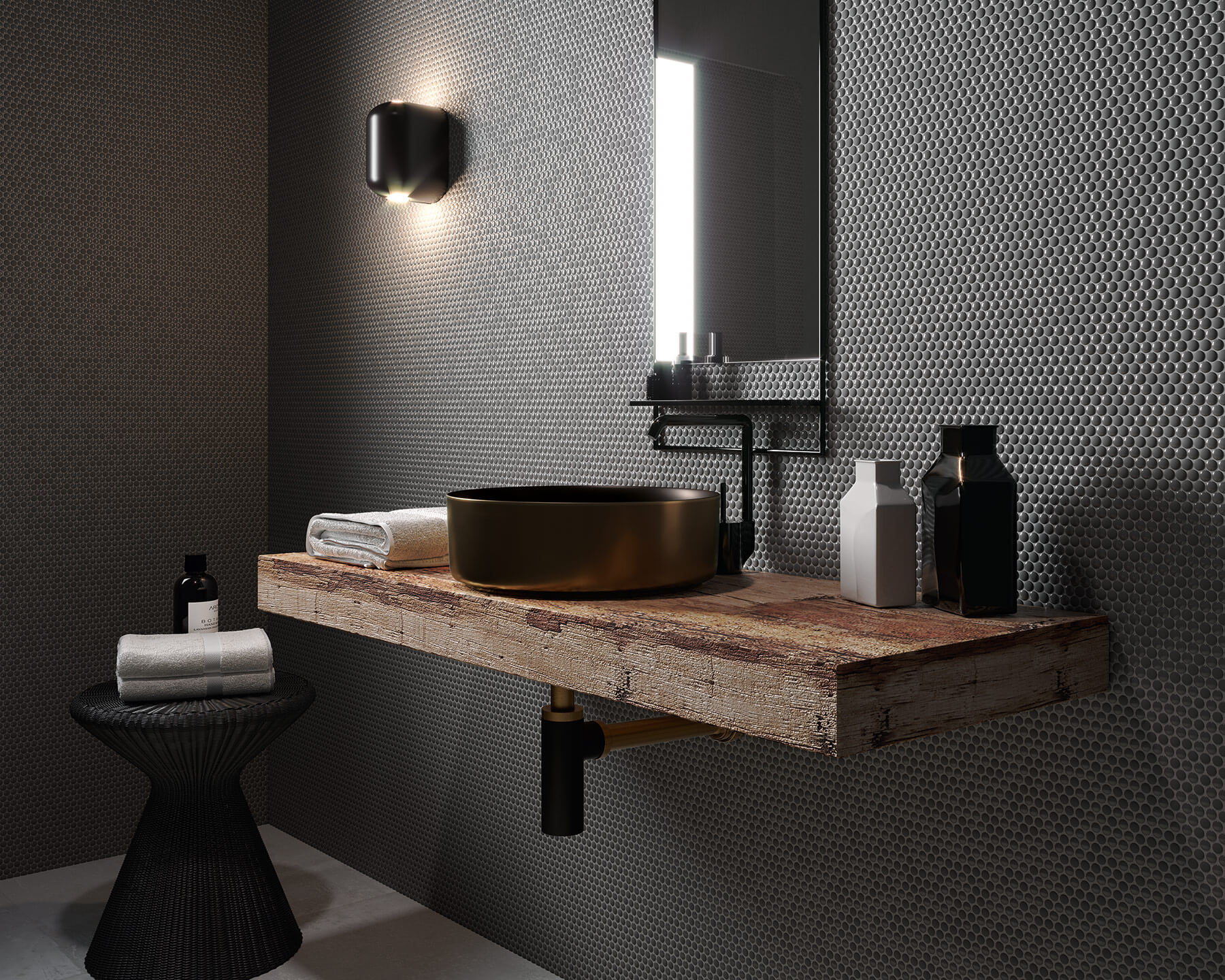 Dark modern bathroom with timber vanity top, black tapware and basin, and small black circular mosaic tiles over the whole wall.